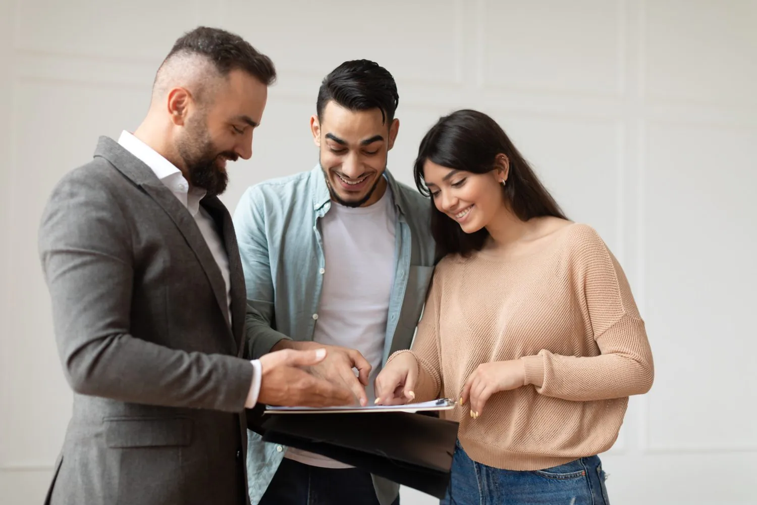 couple-buying-new-apartment-house-agent-showing-document-blueprints