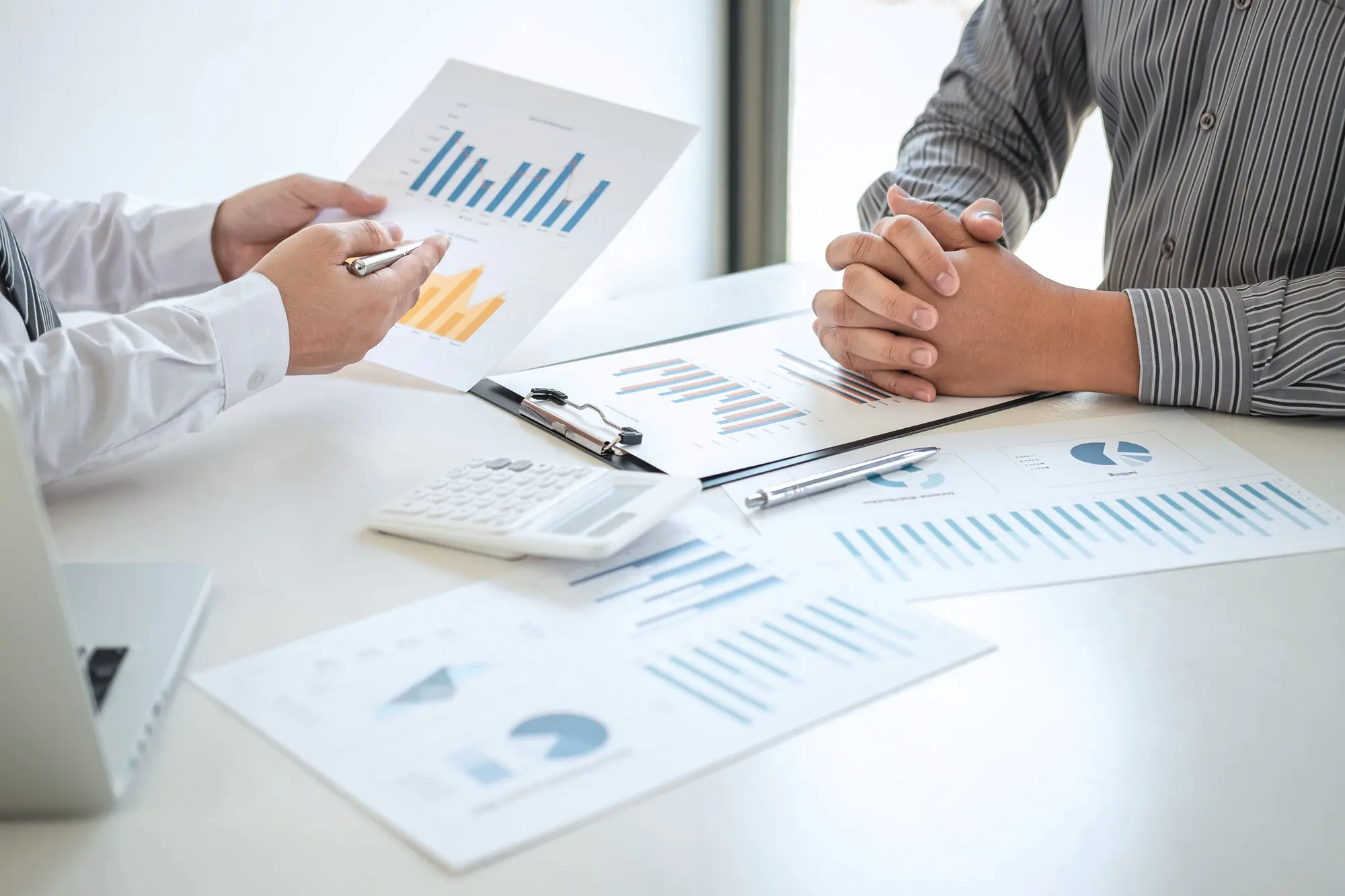 Two-people- discussing-business reports and charts at a desk